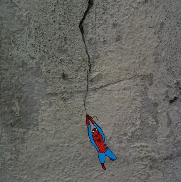 miniature spiderman swinging street art