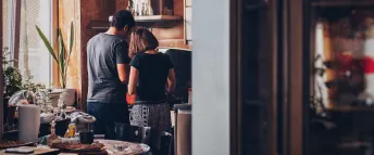 Par står hemma i köket och lagar mat