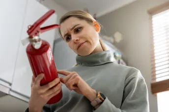 Kvinna läser instruktioner på brandsläckare