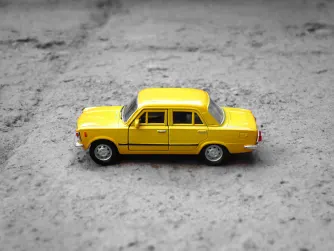 gul leksaksbil med grå bakgrund