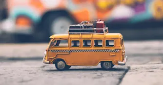 Gul buss med fastspända resväskor.