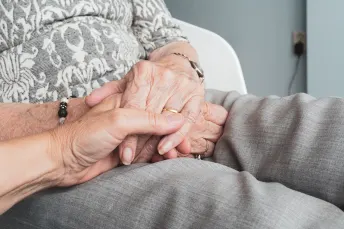 Picture about old person holding hand to younger one. 