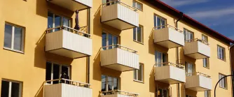 Gult lägenhetshus med vita balkonger