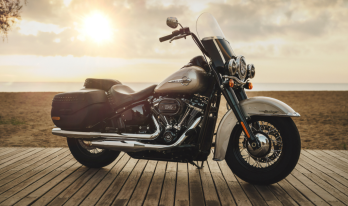 Harley Davidson motorcykel vid strand i motljus. 
