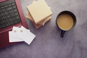 kreditkort på dator med kaffe och sticky notes
