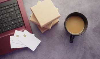 kreditkort på dator med kaffe och sticky notes