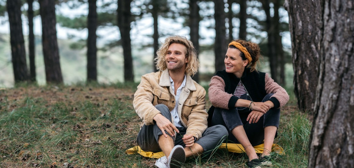 man en vrouw zitten in bos