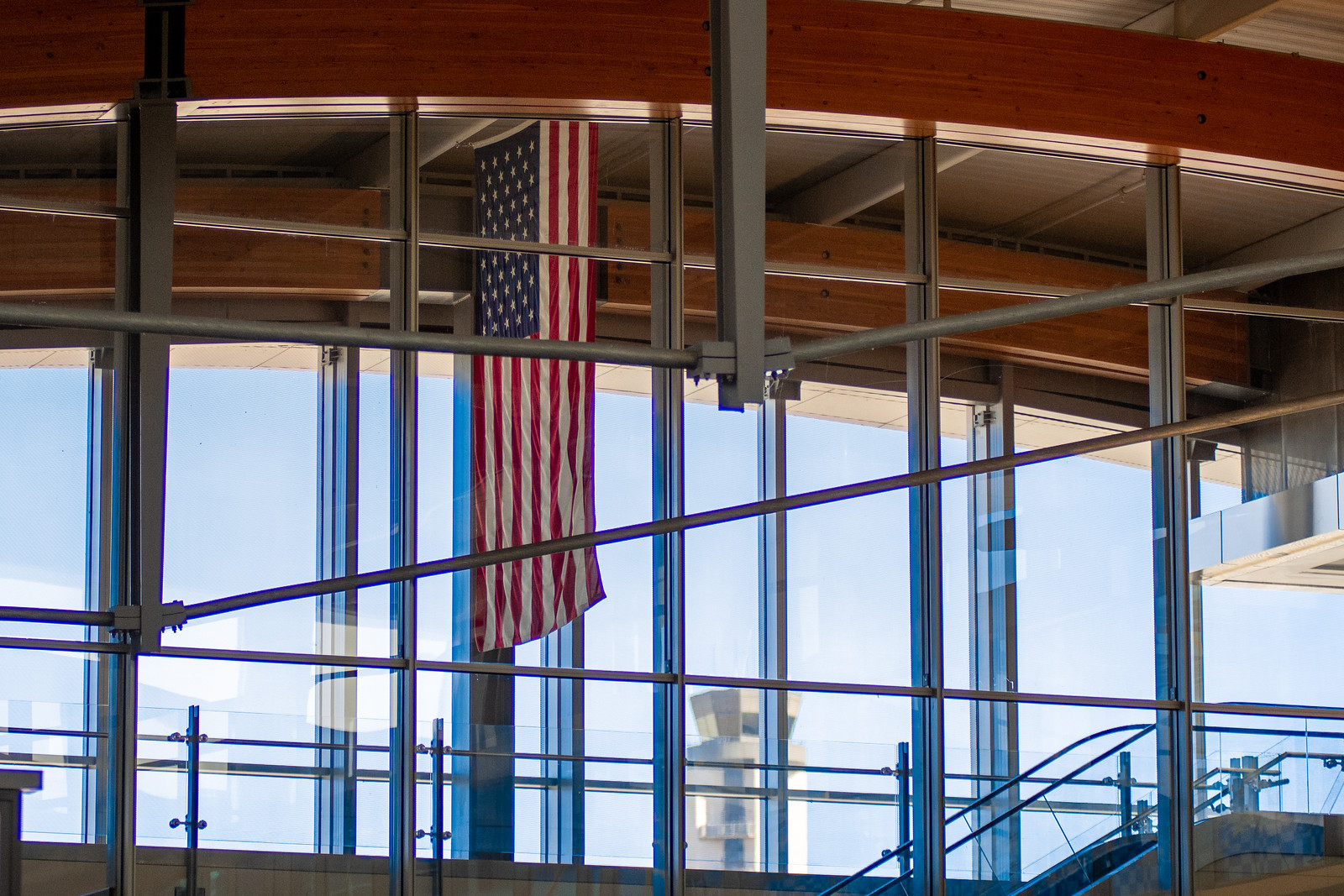 American flag hanging inside a building under construction with exposed wooden beams and metal framework visible.