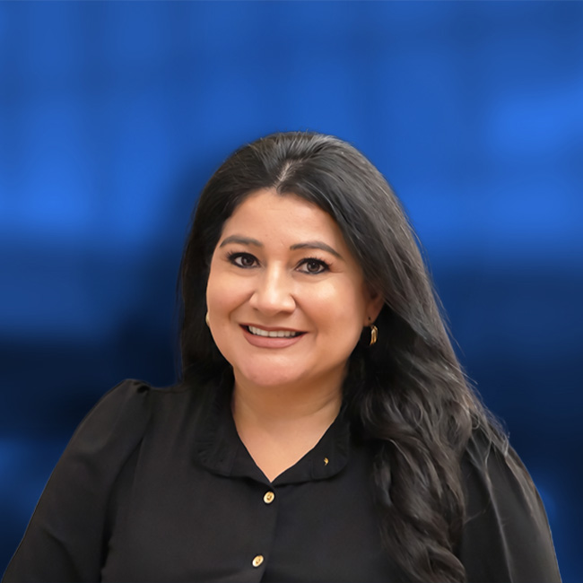 Woman with long dark hair wearing black shirt smiling at camera against blue background