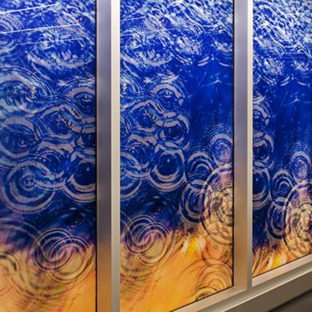 Four vertical glass panels with blue and orange gradient showing water ripple patterns in white circular designs