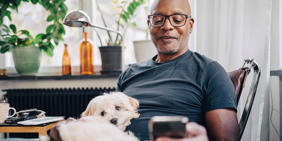Man sitting with his dog looking at cellphone 