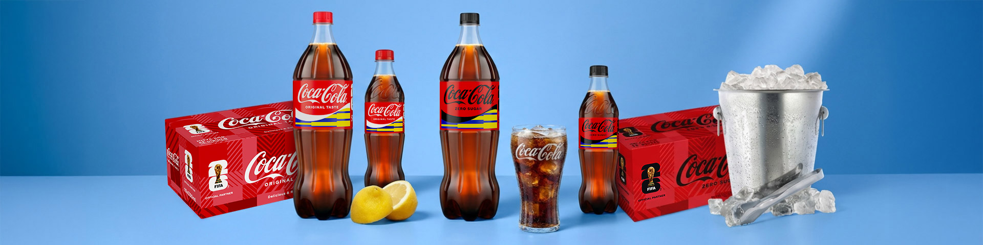 Coca-Cola-flaskor i olika storlekar samt förpackningar, glas med is och dryck, citronhalvor och ishink med is. Klicka för att handla.