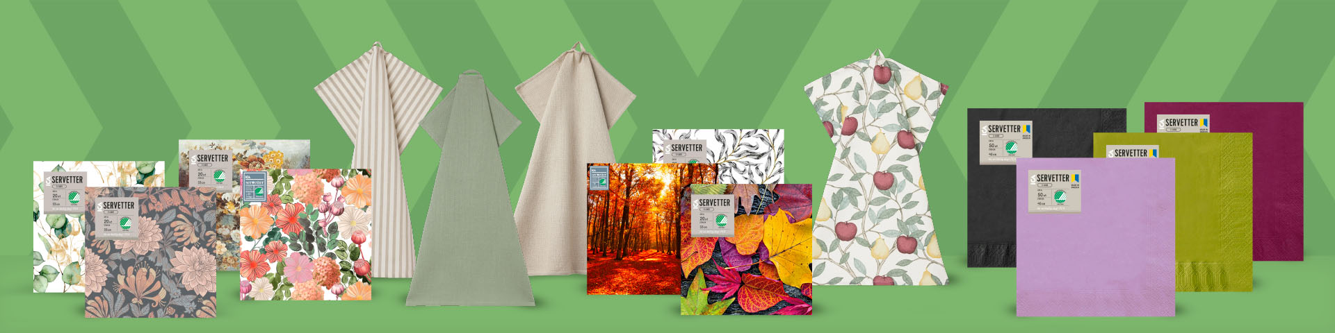 Olika servetter och kökshanddukar med blommiga, mönstrade och enfärgade motiv uppställda på rad, flera servettförpackningar märkta med Svanen.