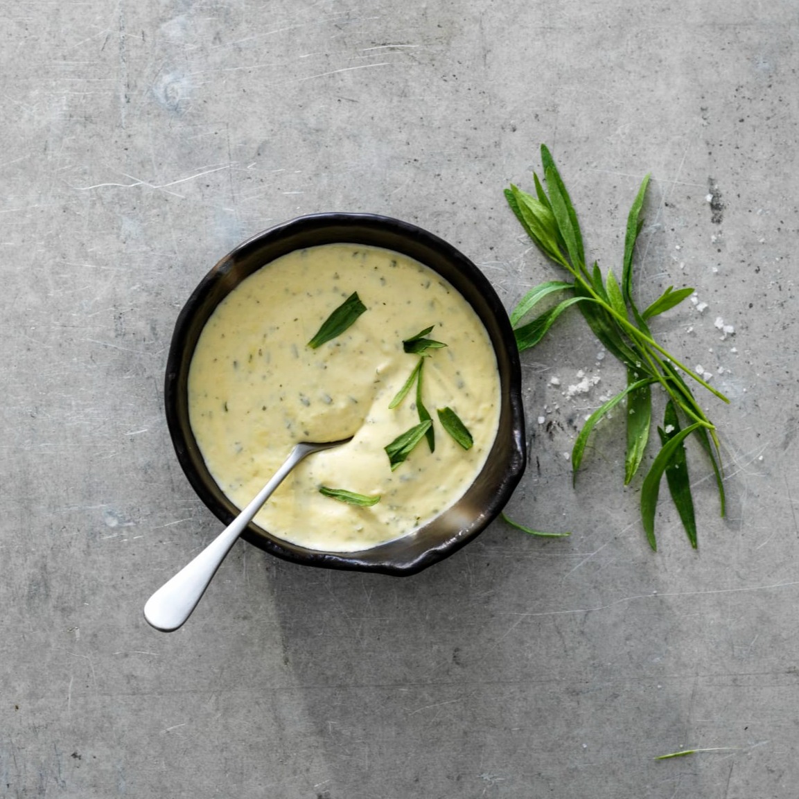 Enkel bearnaisesås i en skål, med dragon som dekoration både på såsen och bredvid skålen. 