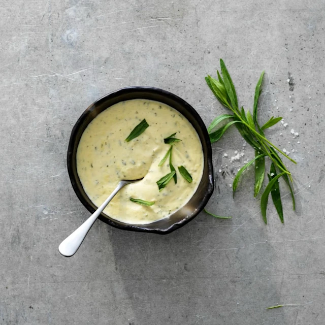 Enkel bearnaisesås i en skål, med dragon som dekoration både på såsen och bredvid skålen.