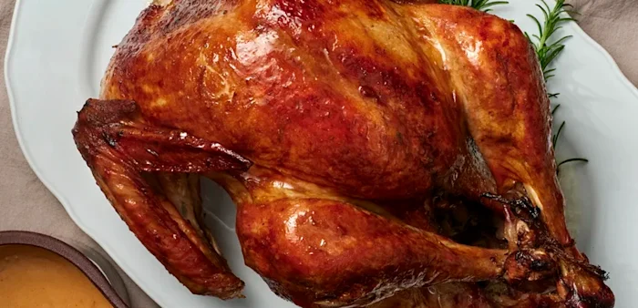 Ett stort vitt fat med en grillad kalkon.