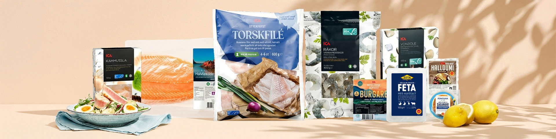 Olika fisk- och skaldjursprodukter, ost och citroner på ett bord. Klicka för att handla fisk, skaldjur och ost till grillen.