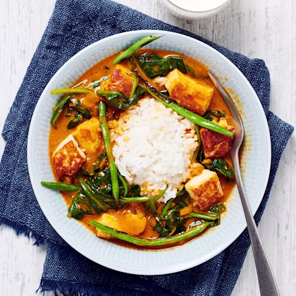 spenatcurry med halloumi och ris. Ett glas mjölk står bredvid