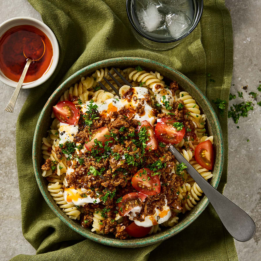 Djup tallrik med pastaskruvar och köttfärs. Toppad med köttfärs, tomater och persilja. 