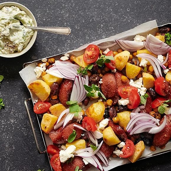 En plåt med klyftade grönsaker och fetaost