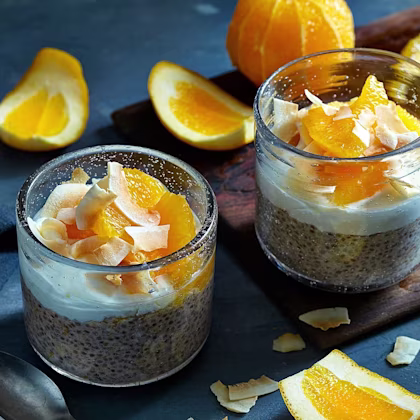 Glas med en pudding av chiafrön, toppade med yoghurt, apelsin och kokos.