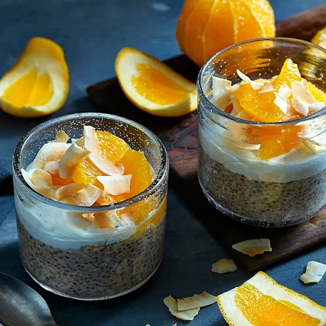 Glas med en pudding av chiafrön, toppade med yoghurt, apelsin och kokos.