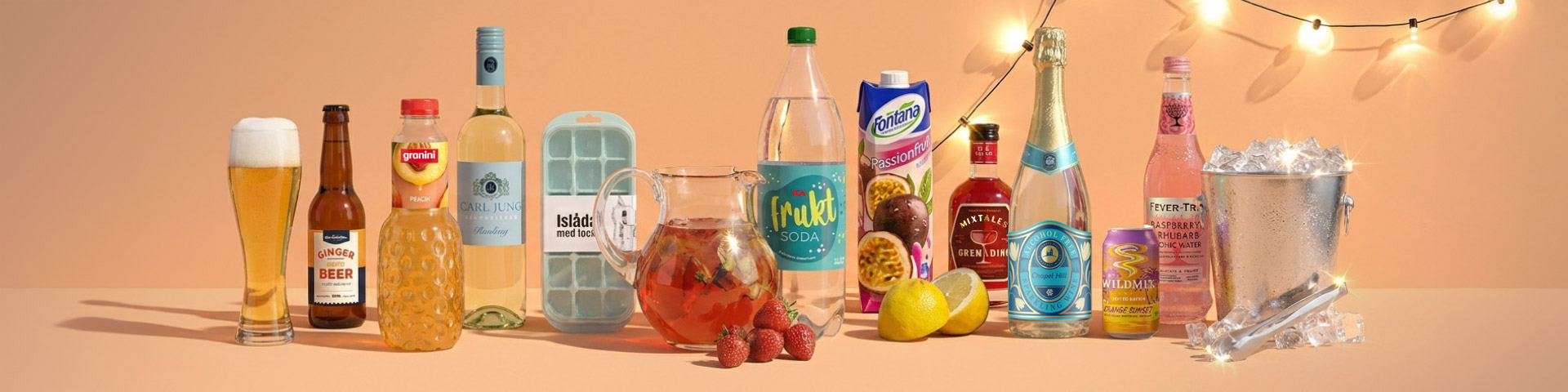Uppdukning med olika drycker och tillbehör: ölglas, ginger beer, juice, vitt vin, isform, kanna med bär, läsk, lemonad, bitters, mousserande vin samt ishink med is.