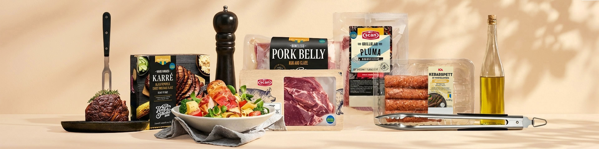 Olika köttprodukter, olivolja, pepparkvarn och grilltång på ett bord. Klicka för att handla kött att grilla.