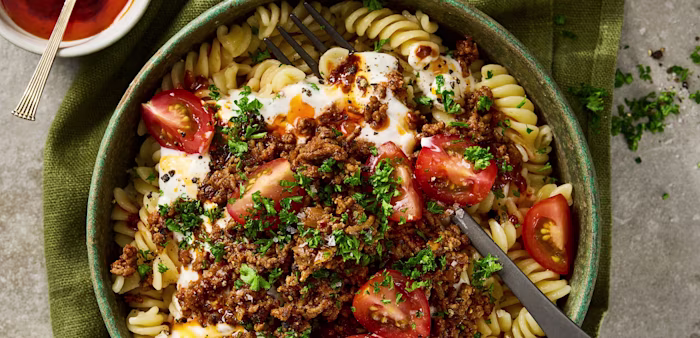 Djup tallrik med pastaskruvar och köttfärs. Toppad med köttfärs, tomater och persilja.