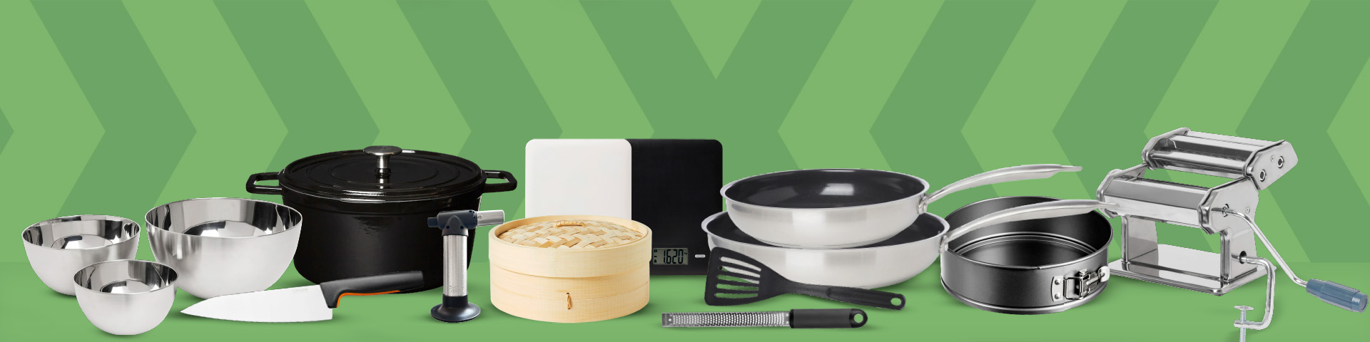 Olika köksredskap och köksmaskiner som skålar, gryta, kniv, gasbrännare, ångkokare, våg, stekpannor, slickepott, rivjärn, springform och pastamaskin uppställda på rad. Klicka för att handla.