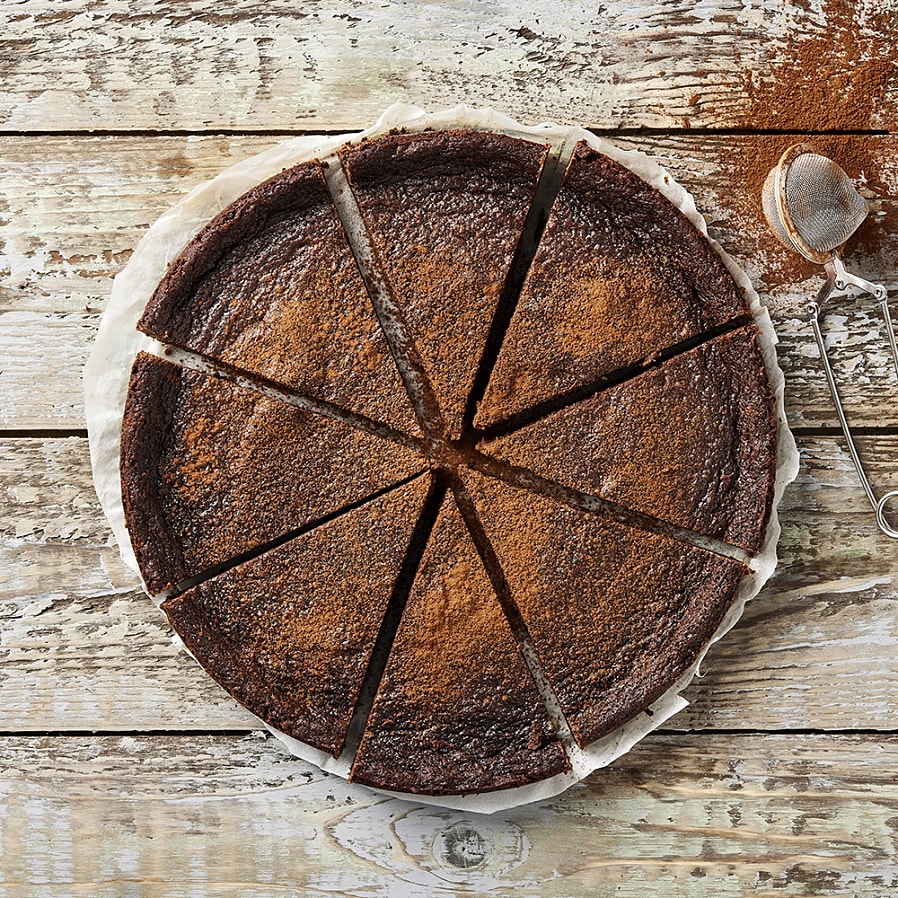 En mörk kladdkaka uppdelad i bitar.