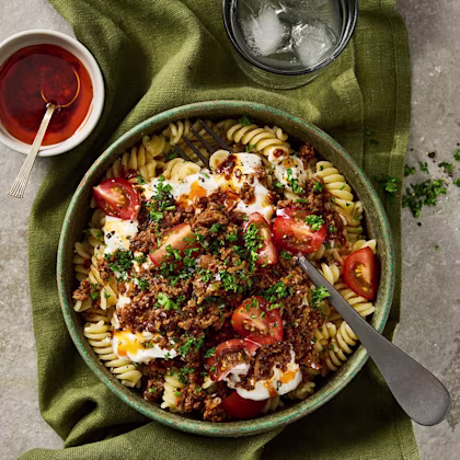 Pasta i skruvform upplagd i en djup tallrik med tomat, köttfärs och örter. Klicka för att se fullständigt recept.