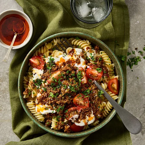 Pasta i skruvform upplagd i en djup tallrik med tomat, köttfärs och örter. Klicka för att se fullständigt recept.