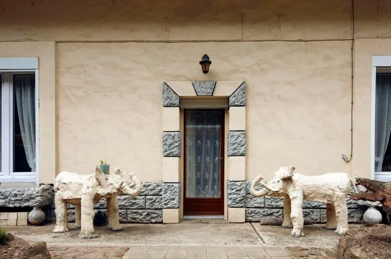 Deux éléphants en ciment encadrent l'entrée de sa maison