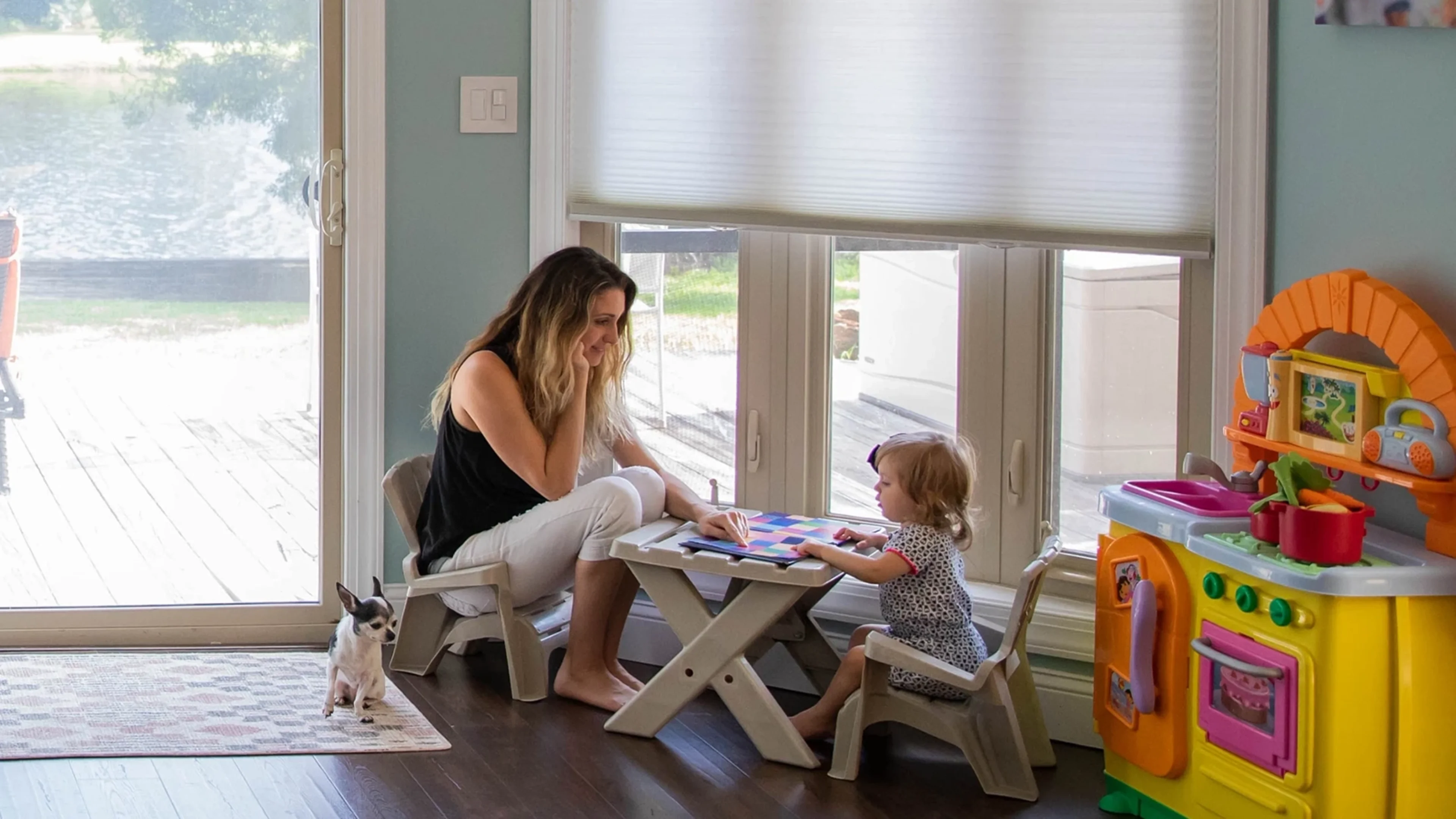 Mother and child playing together in a playroom with child safe blinds.