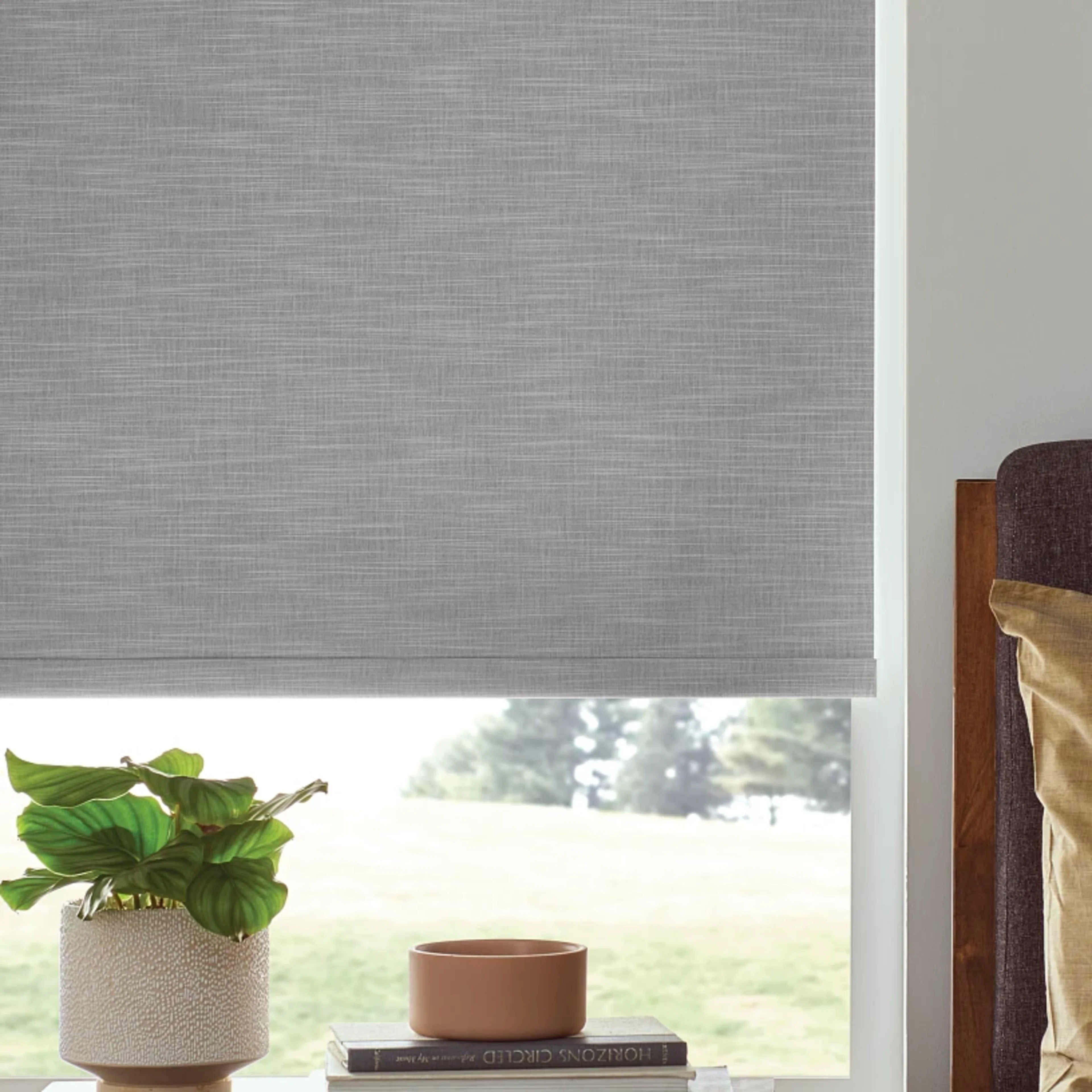 Close up of a roller shade in a tall window.