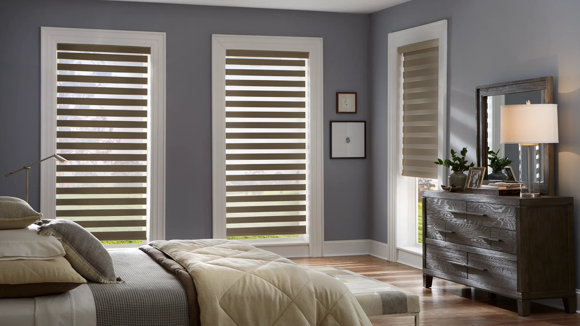 Three motorized banded shaded on tall windows in a bedroom.