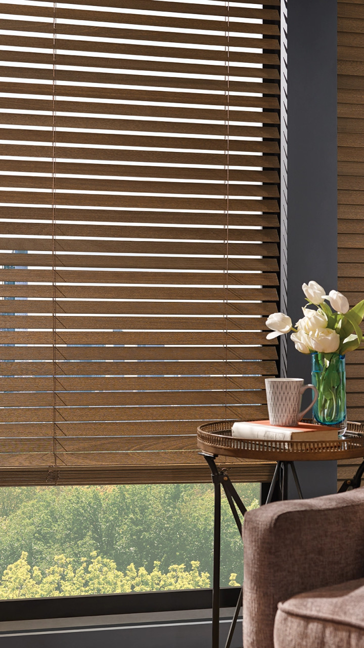 Wood blinds featured in a bedroom.