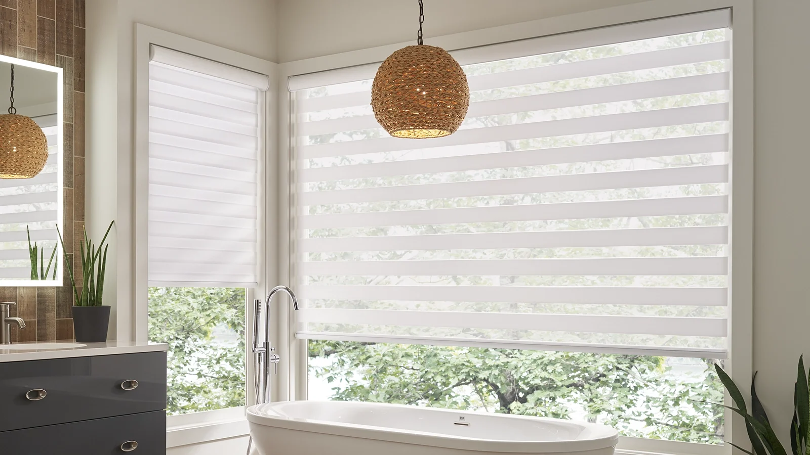 Bright sun filled bathroom featuring motorized white banded shades. 