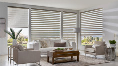Four motorized gray banded shades in a brightly lit living room.