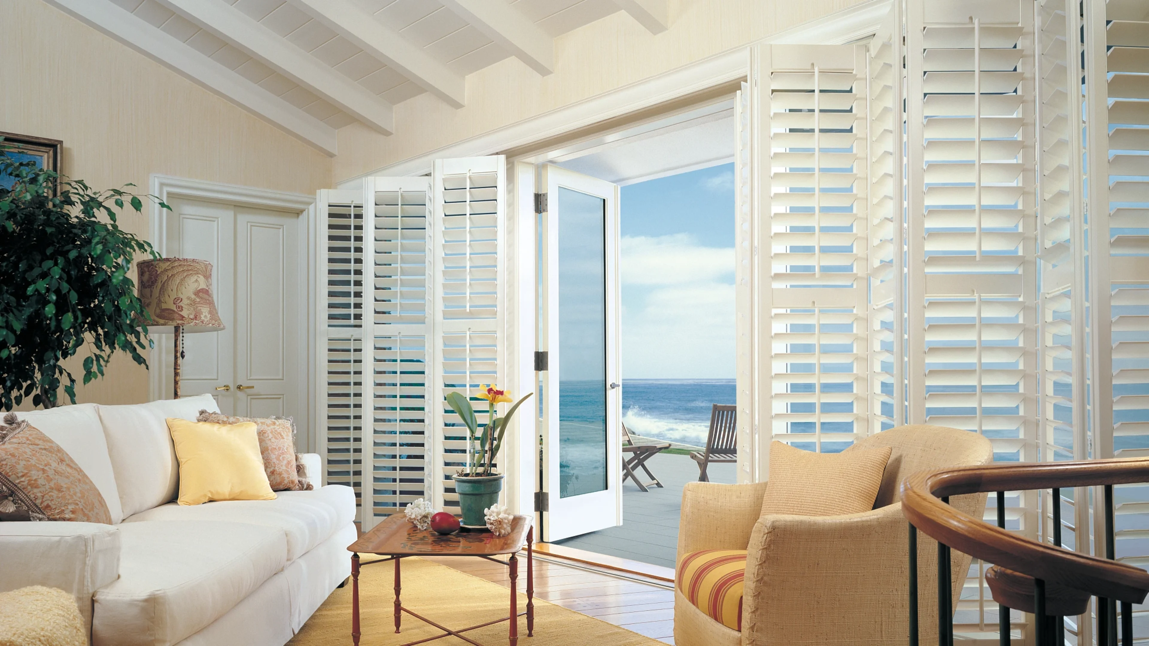 Composite bifold shutters in living room with french doors.