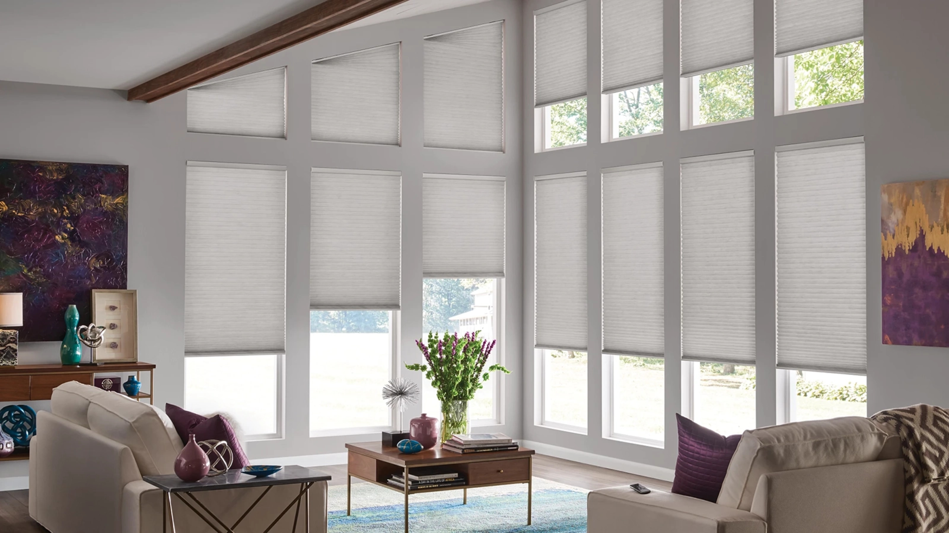 Large, bright, open, contemporary living room featuring motorized, specialty shape honeycomb shades.