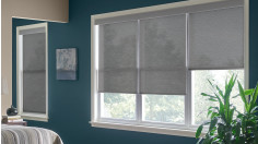 Gray cordless roller shades in a bedroom.