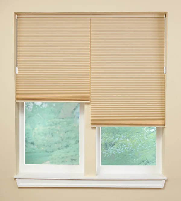 Two wand operated motorized honeycomb shades installed on a single headrail.
