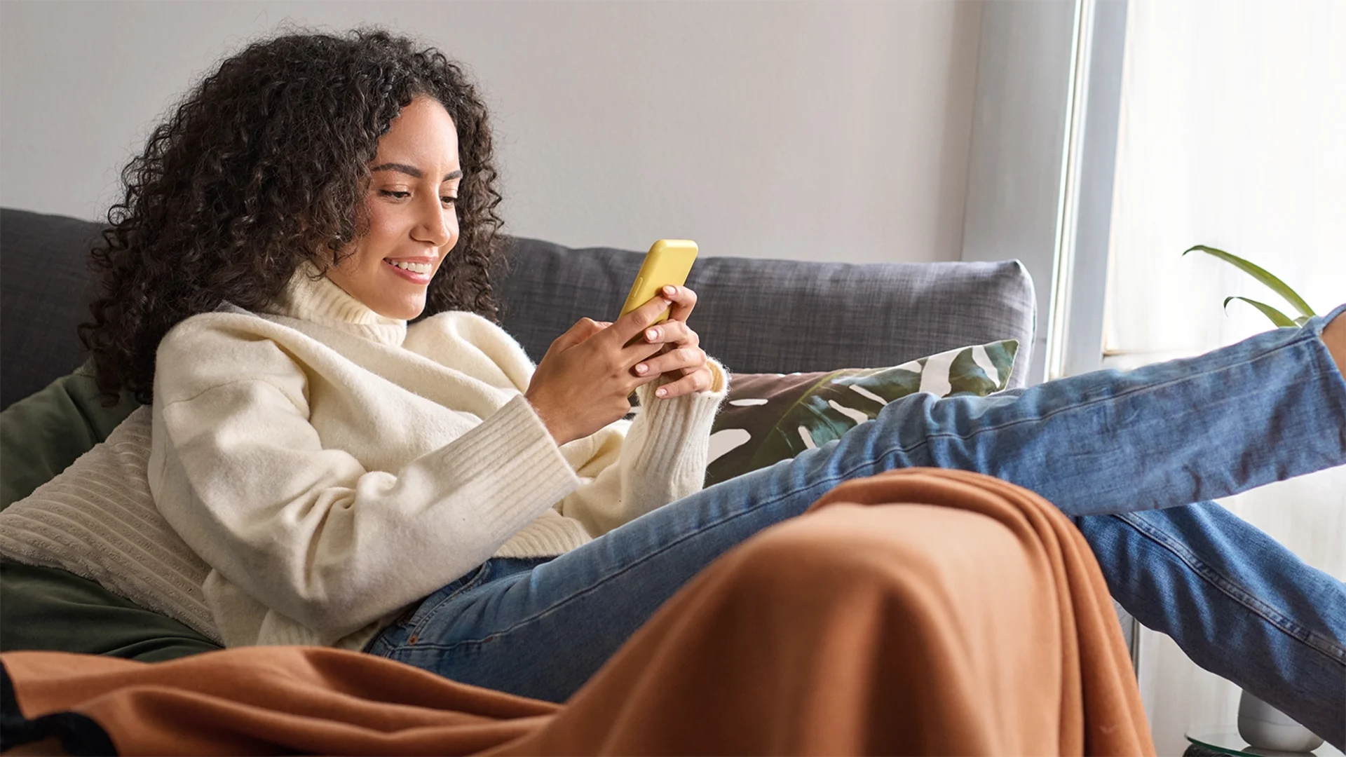 woman browsing on her phone for window treatments