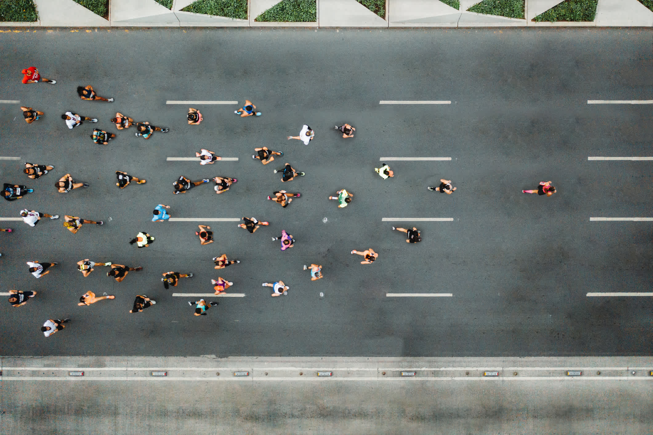 Aerial view of marathon city runners. One person leading marathon. | Watermark

