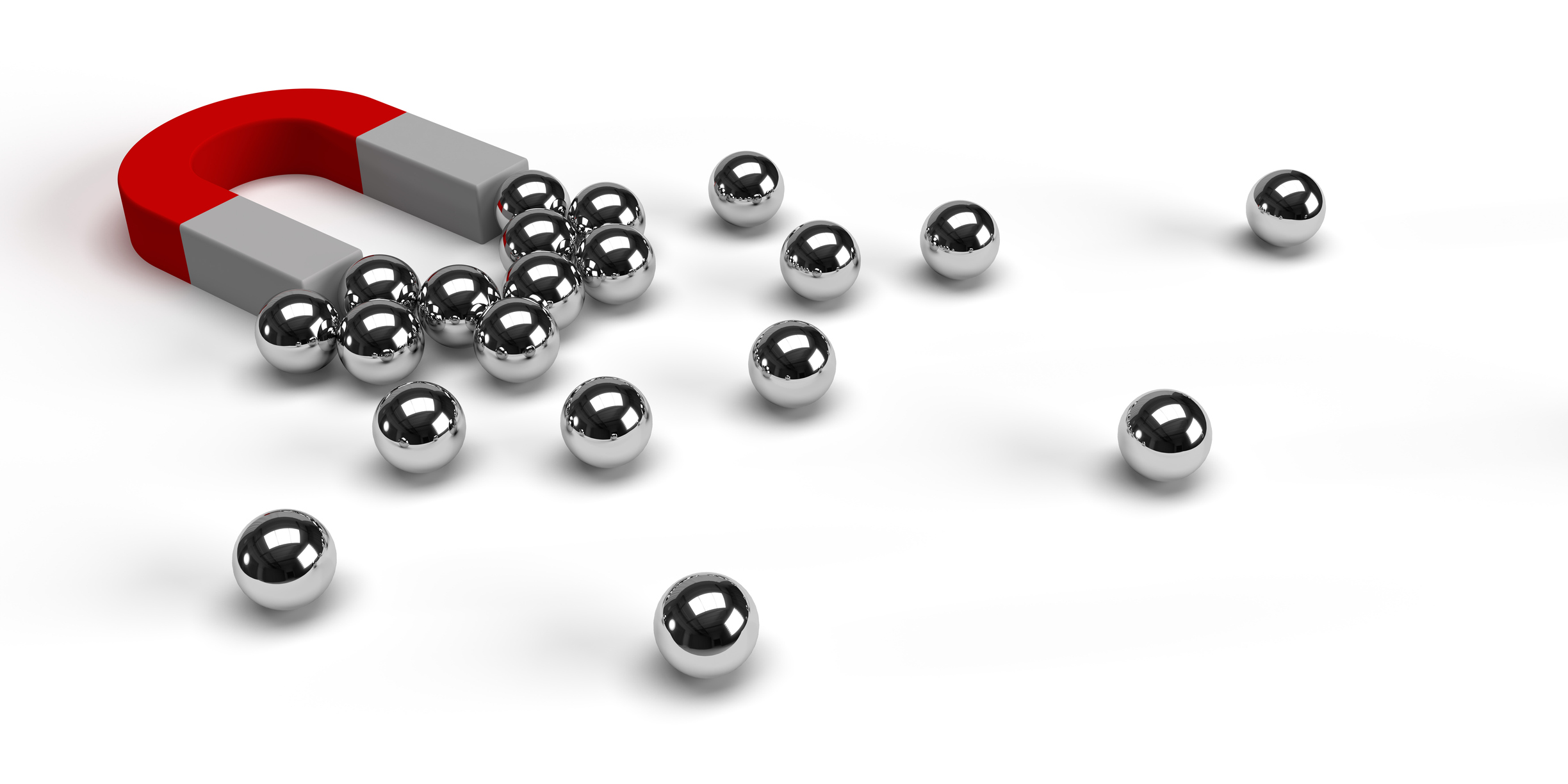 Digital marketing and global business concept. Small silver spheres gravitated towards a magnet on isolated white background. Large copy space. | Watermark