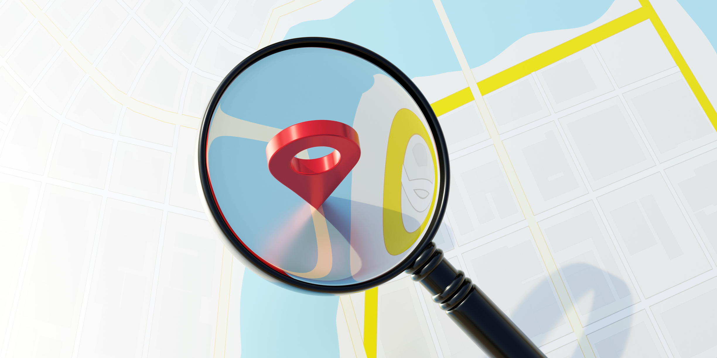 A magnifying glass over a pin in a map that represents local SEO. 