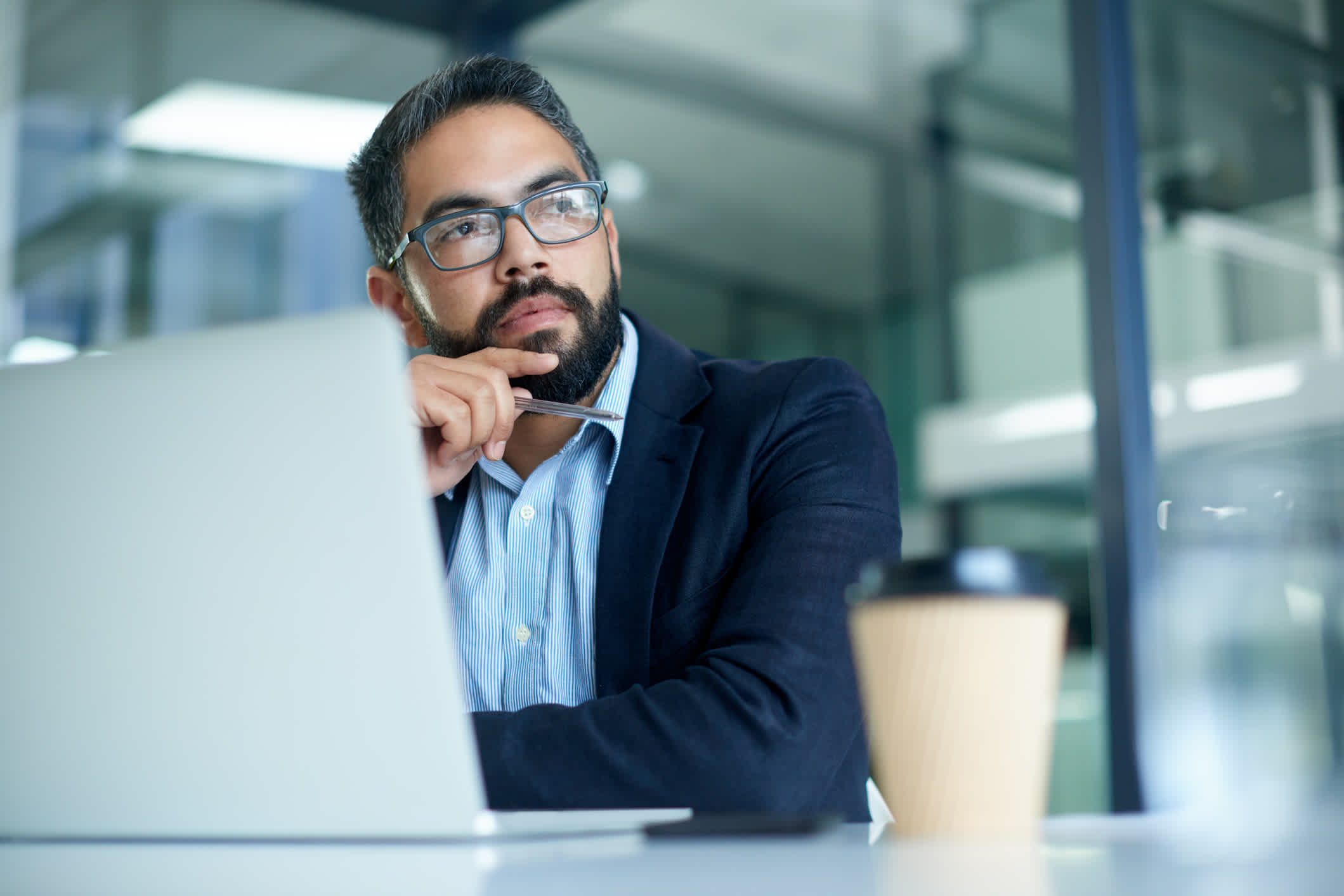 person thinking at a laptop