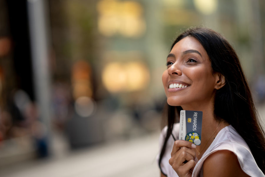 Happy shopping woman holding a rewards card